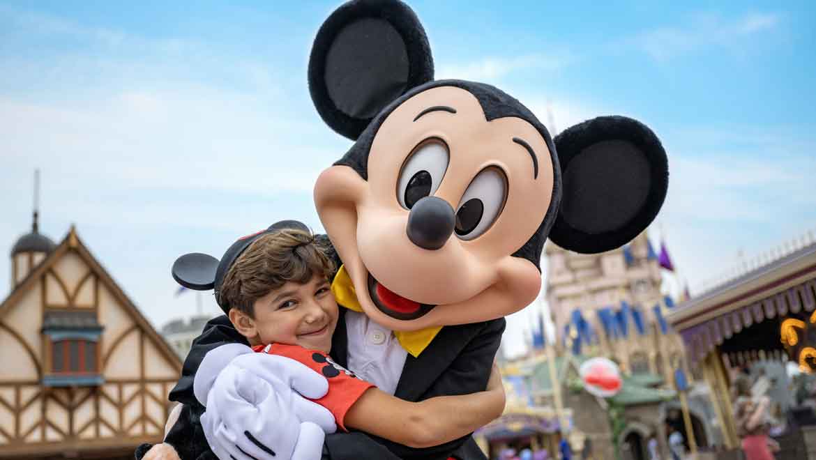 Child hugging Mickey Mouse.