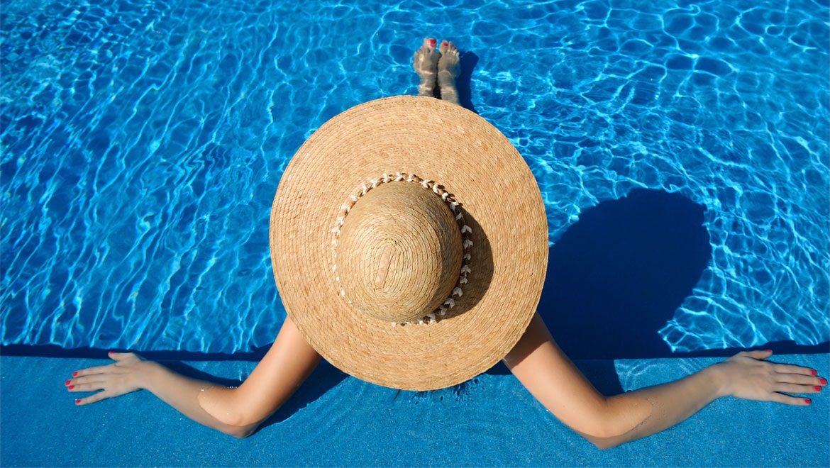 Woman in a sun hat in the pool