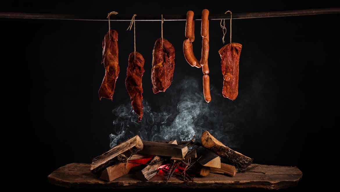 Meat hanging over fire.