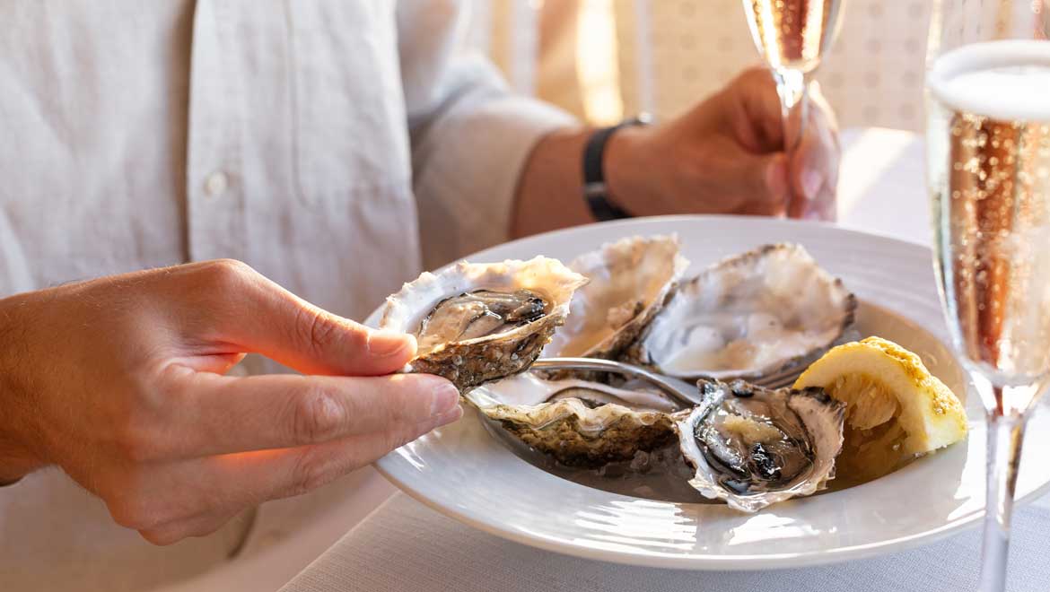 Person holding raw oyster