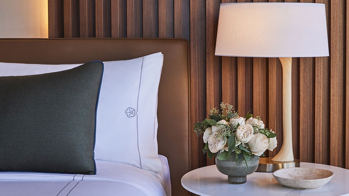 Omni pillows and nightstand with flowers.