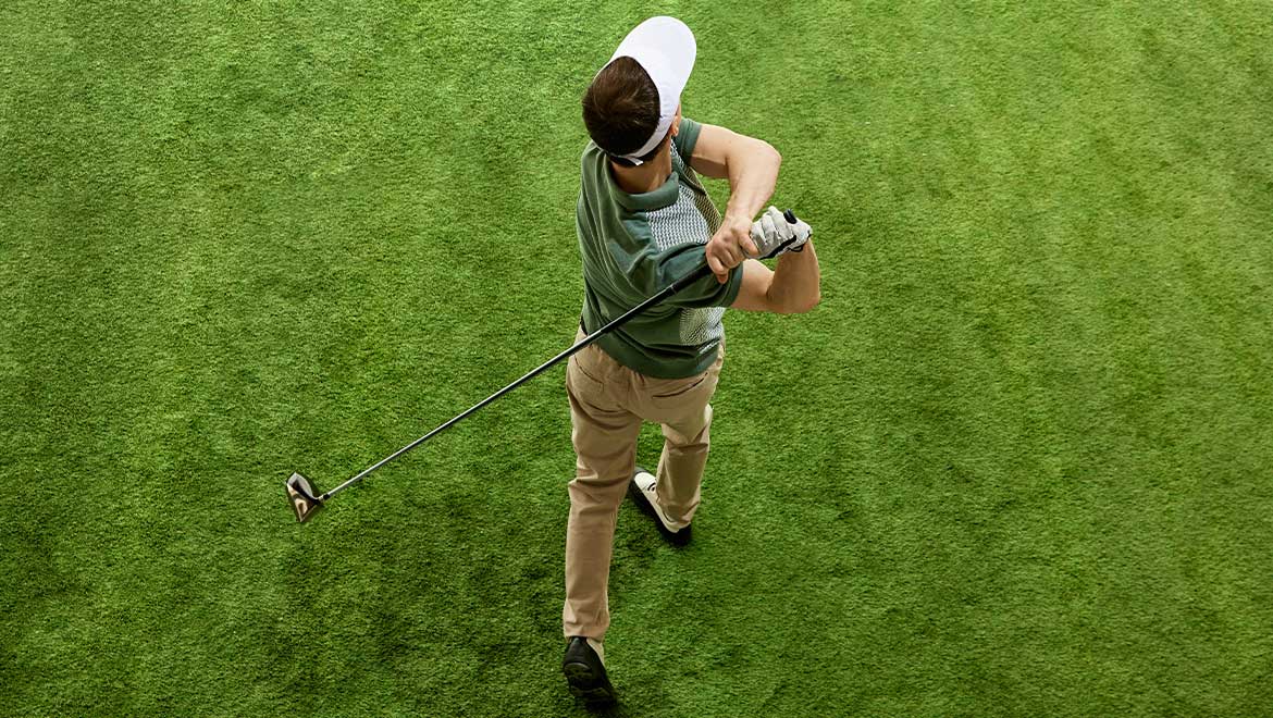 Overhead angle view of golfer hitting golf ball