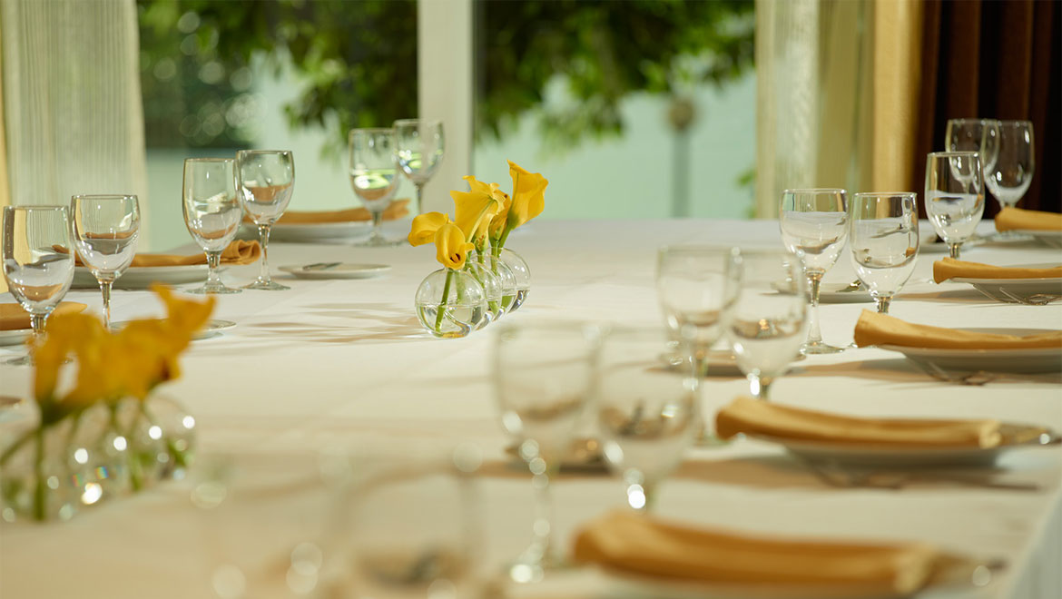 Table setting with glasses and yellow flowers