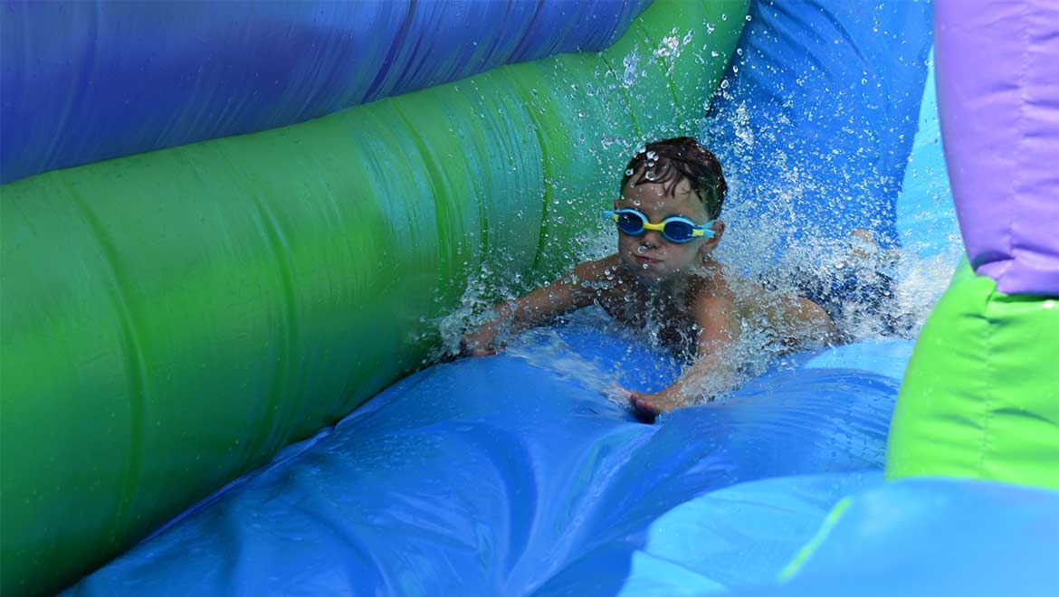 Kid sliding down inflatable water slide