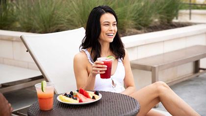 Woman enjoying drinks by the pool