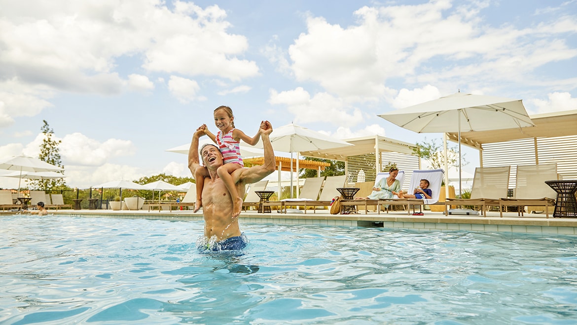 dad and daughter playing in pool