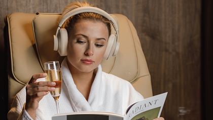 Woman listening to headphones in spa robe.