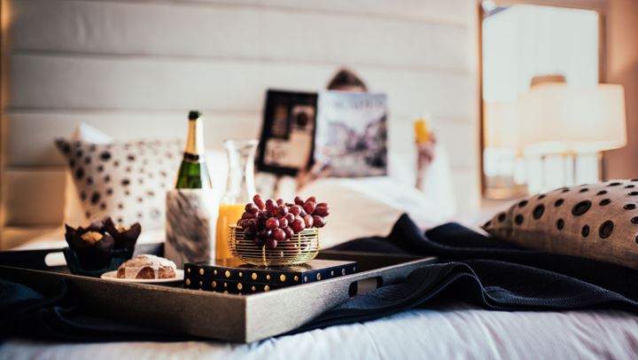 Tray of food on bed.