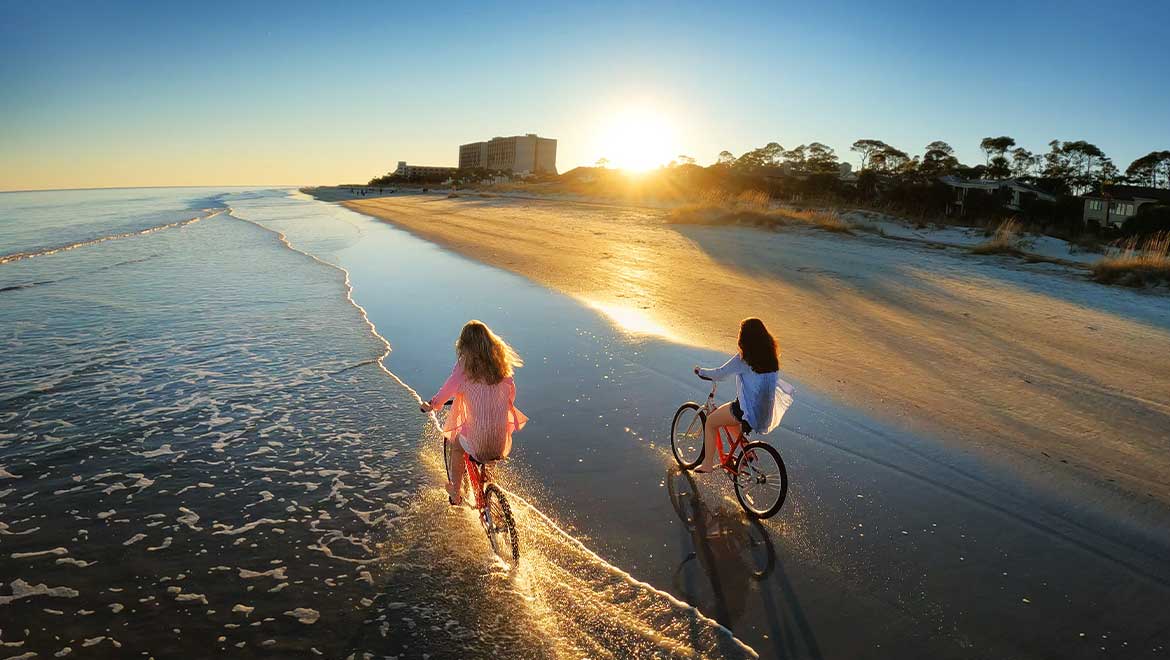 Kids bike riding along the beach