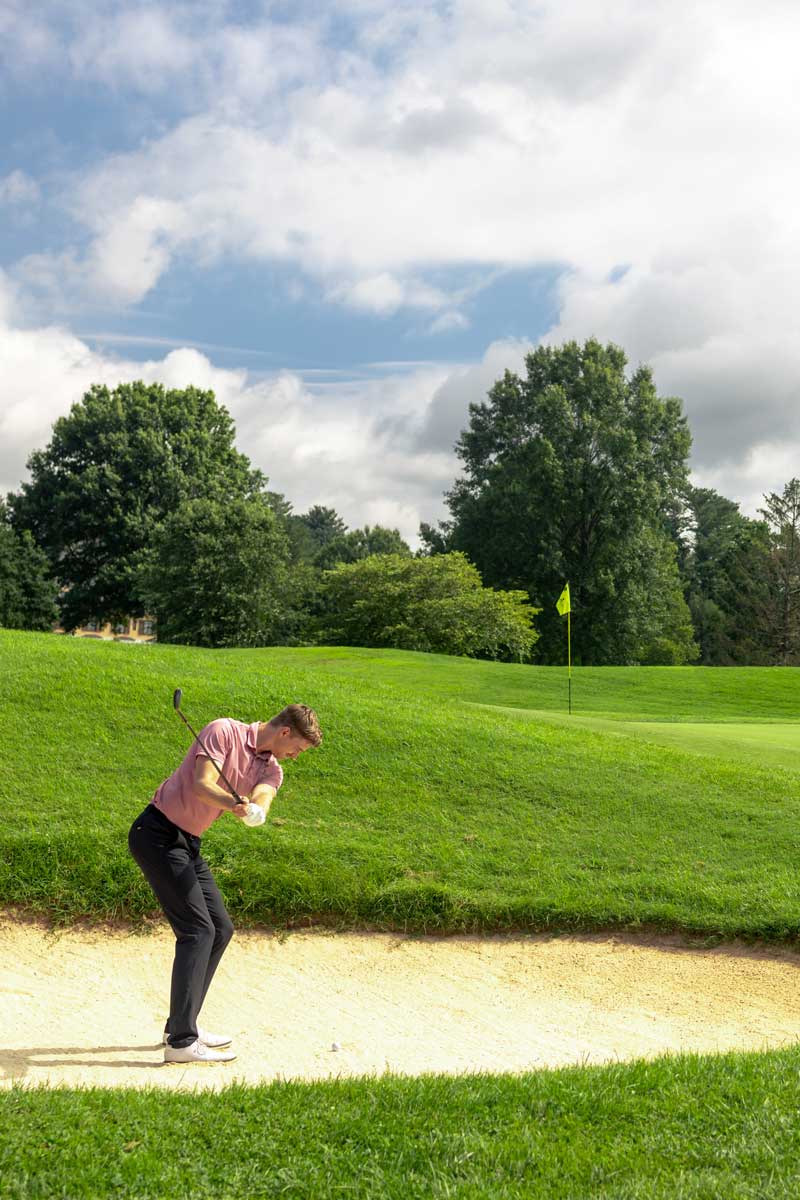 Golfer hitting out of the sandtrap