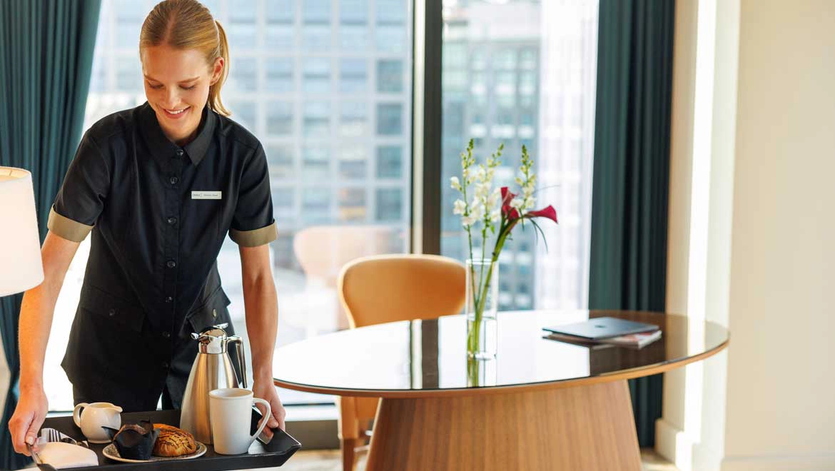 Woman delivering breakfast in room.