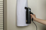 Hand steamer being used on clothing